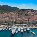 Hvar port waterfront with small boats, town quay and historic buildings along the coast
